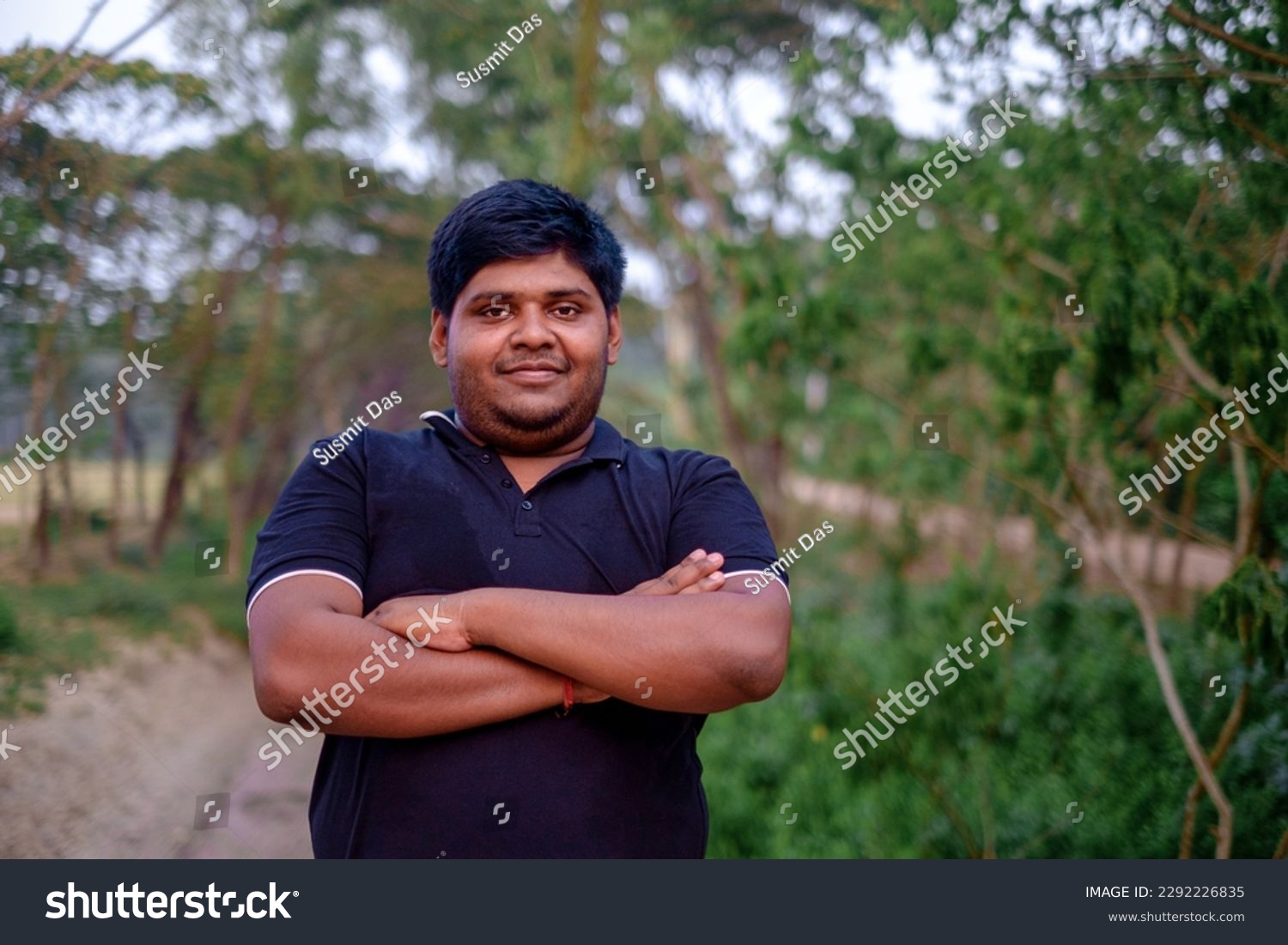 stock-photo-south-asian-overweight-young-man-standing-within-green-natural-environment-2292226835.jpg