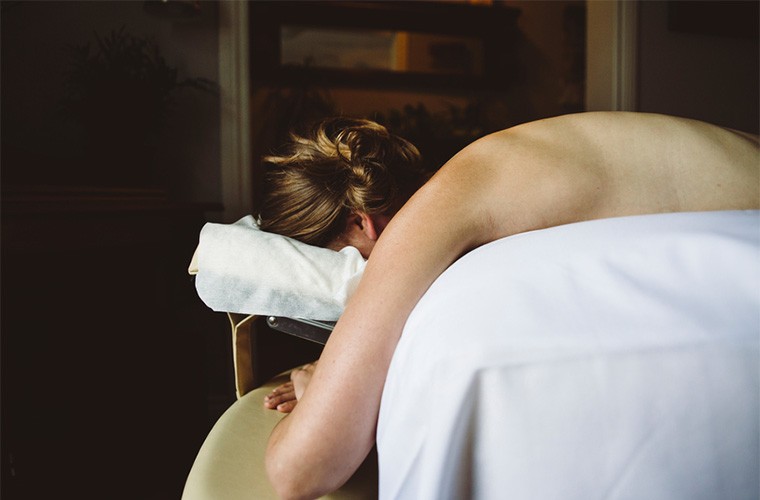 Stocksy-Lisa-MacIntosh-bare-backed-woman-resting-face-down-on-massage-table.jpg