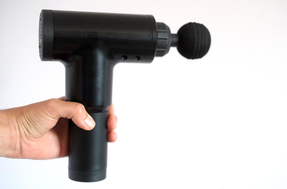 A low-cost Rybozen massage gun in-hand.